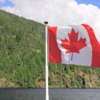 Canadian flag flying high above mountains