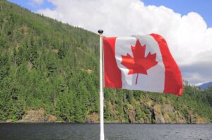 Canadian flag flying high above mountains