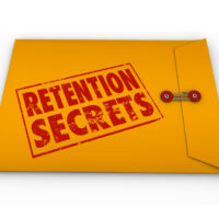 Retention Secrets word stamped in grunge red ink style on a yellow envelope to give you tips and advice on retaining customers or employees