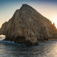 Sun setting over Land's End natural rock formation, El Arco, in Cabo San Lucas, Mexico