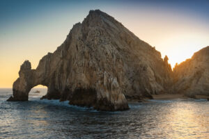 Sun setting over Land's End natural rock formation, El Arco, in Cabo San Lucas, Mexico